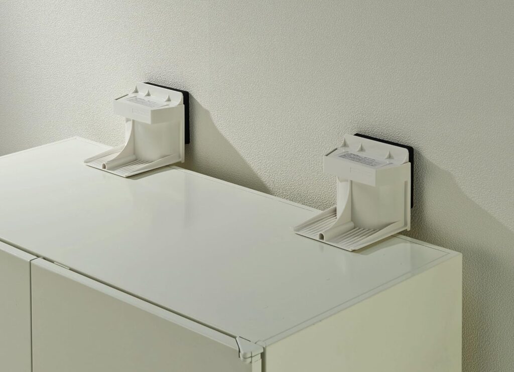 地震の揺れによる家具の転倒を防ぐために、棚と壁の間に取り付けられた家具転倒防止器具。